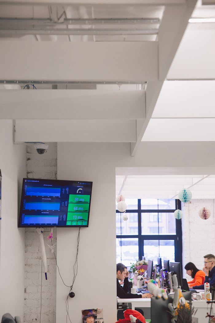 A modern office interior with screens displaying data and colleagues working.